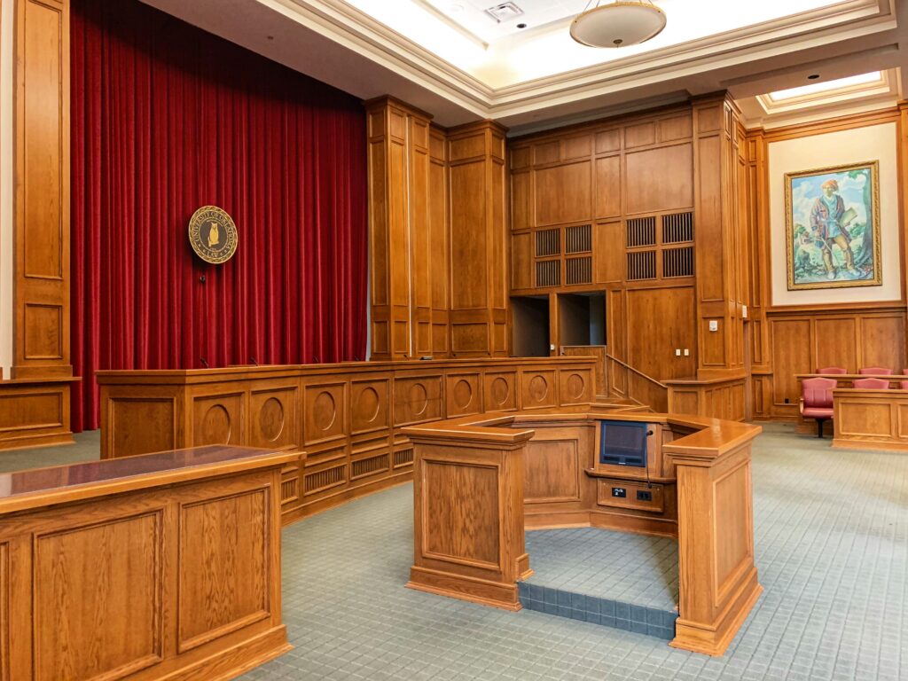 Empty courtroom with judge’s bench, witness stand, and seating.